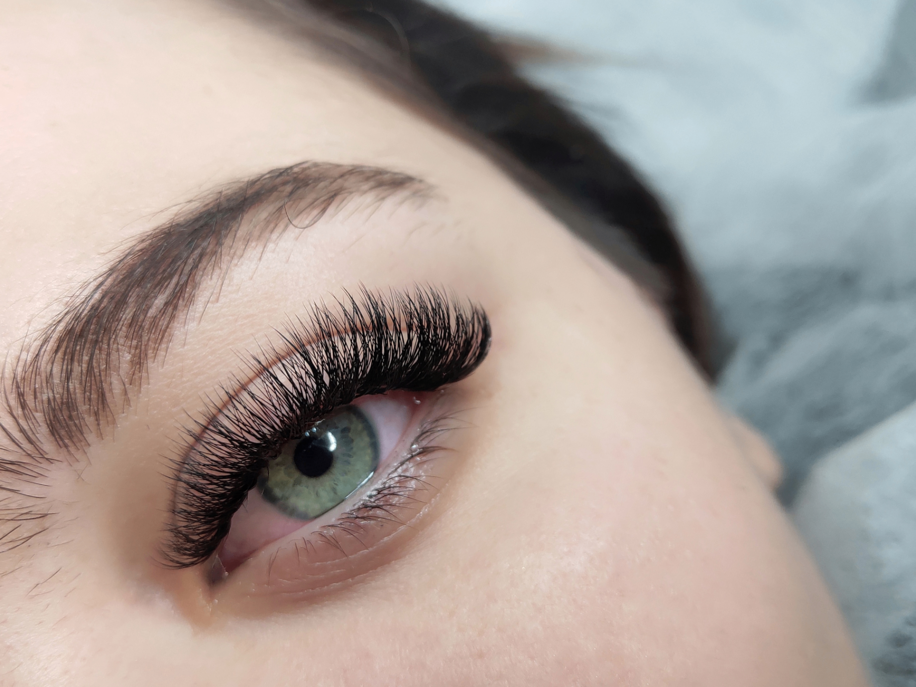 Close-up of eyelash extension styling on a client.